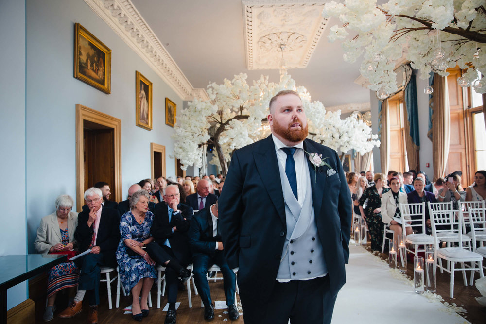 groom stood on top of aisle waiting for bride during haigh hall ceremony
