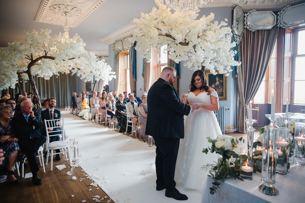 wide angle lens photograph of wedding couple exchanging rings