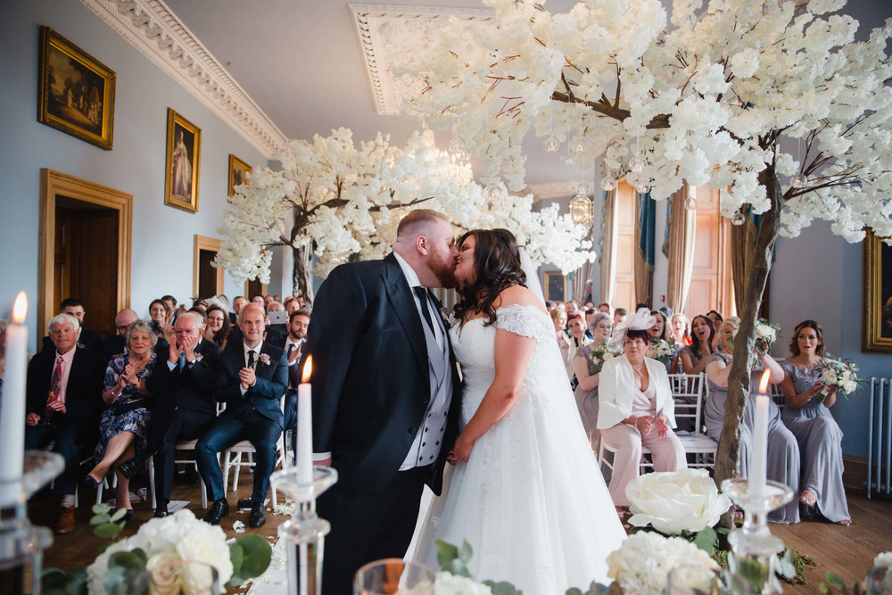 first kiss of bride and groom at haigh hall wedding venue