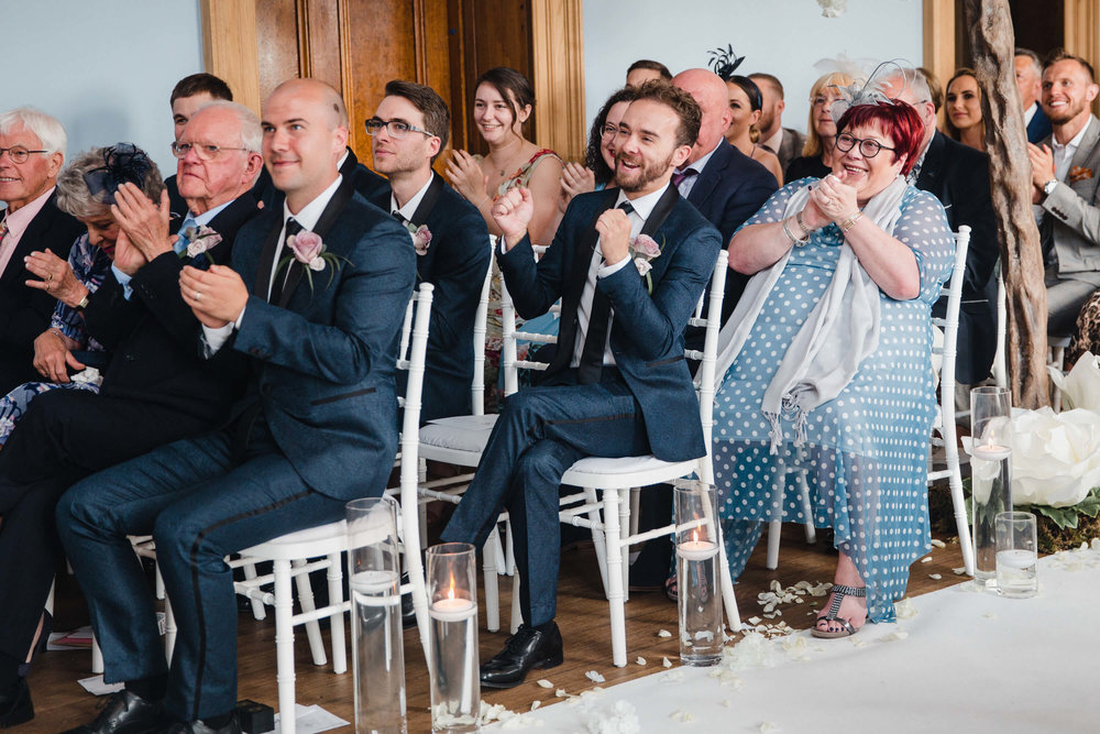 best man cheers for newlyweds at haigh hall