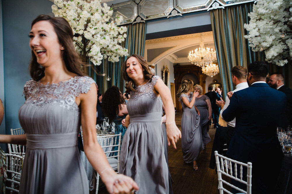 bridesmaids being clapped into wedding breakfast room by guests