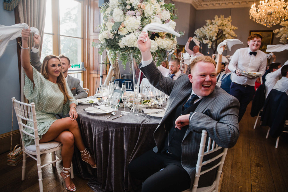 wedding guests waving handkerchiefs while singing