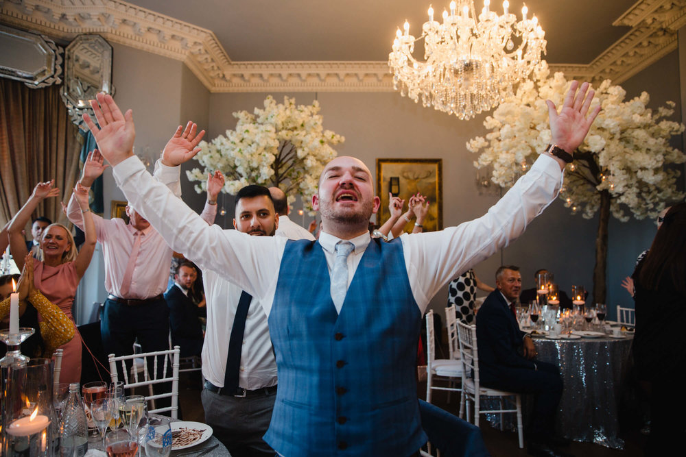 best man waving hands in air while singing