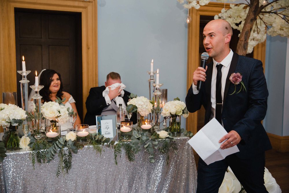 groom with head in hands from embarrassment given by best man