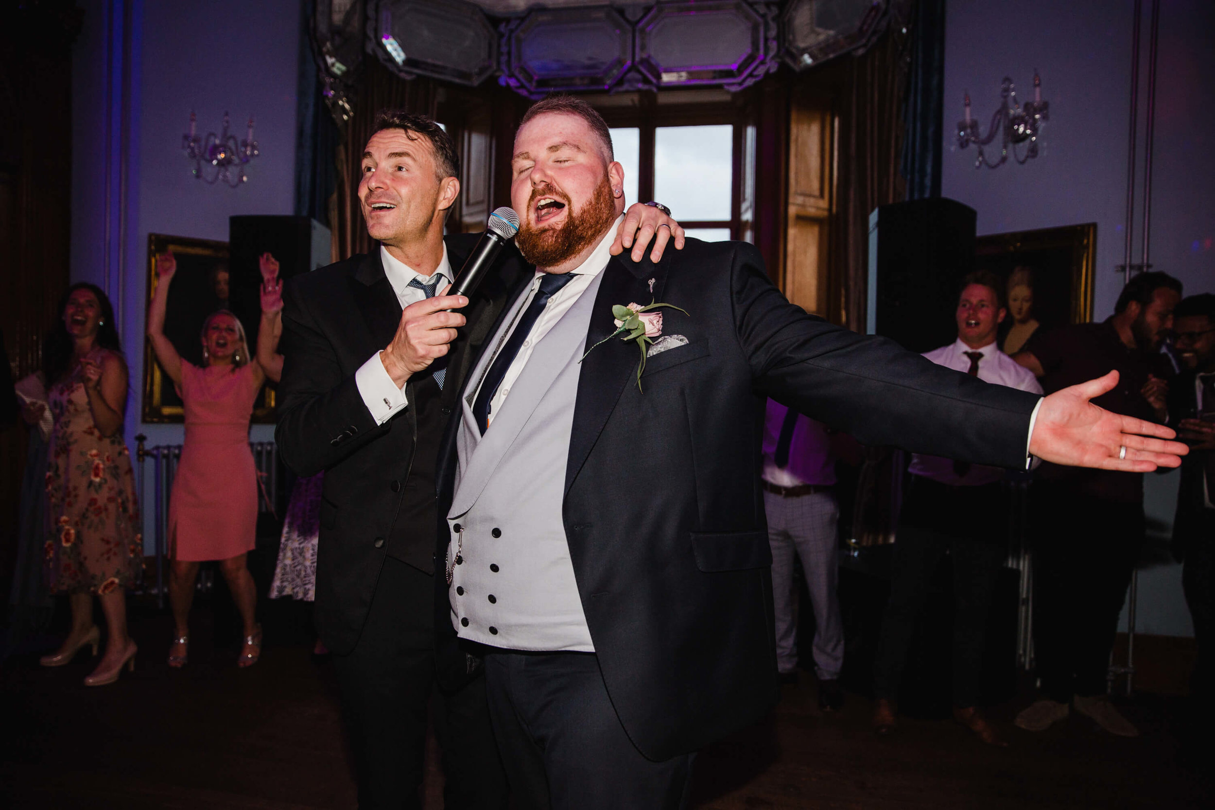 groom singing on dancefloor with howard wing