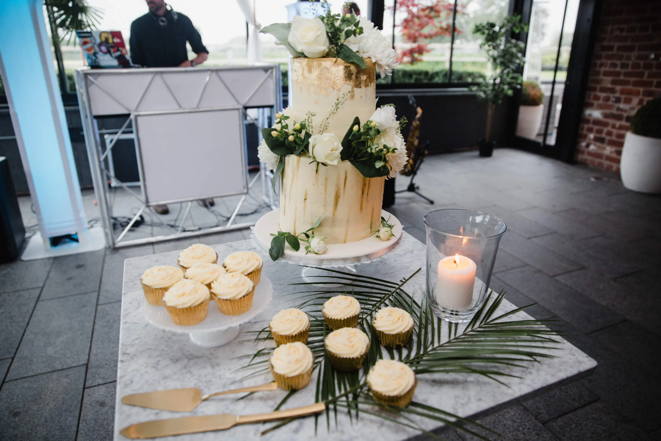 wedding cake and cupcakes dressed with bouquet flowers