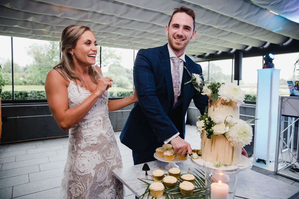 groom cuts in to cake at The Colony Headquarters