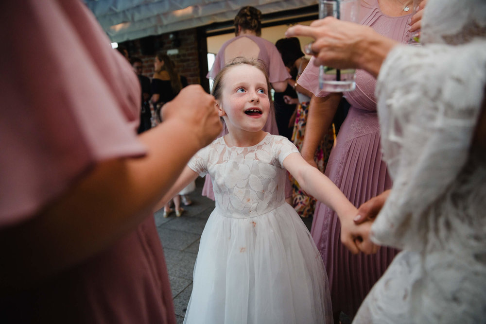 flower girl dancing with bridesmaids