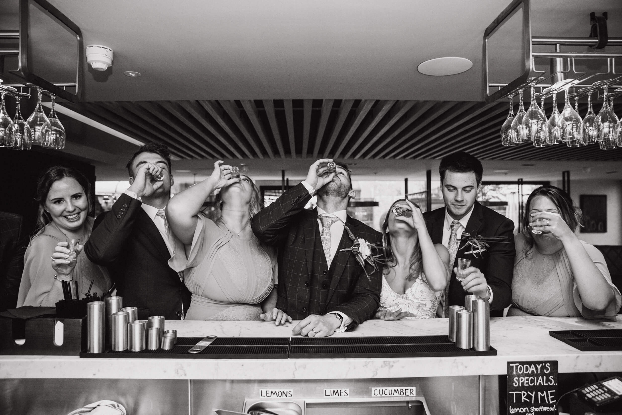 bridal black and white photograph of bridal party drinking at bar of the colony HQ