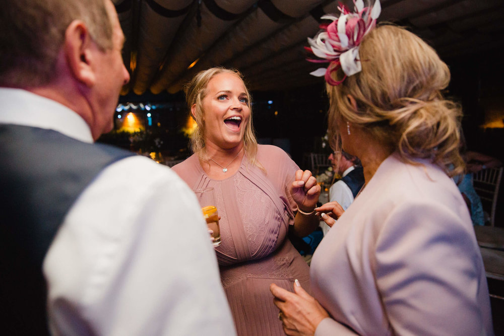 maid of honour sharing joke with bridal party after ceremony