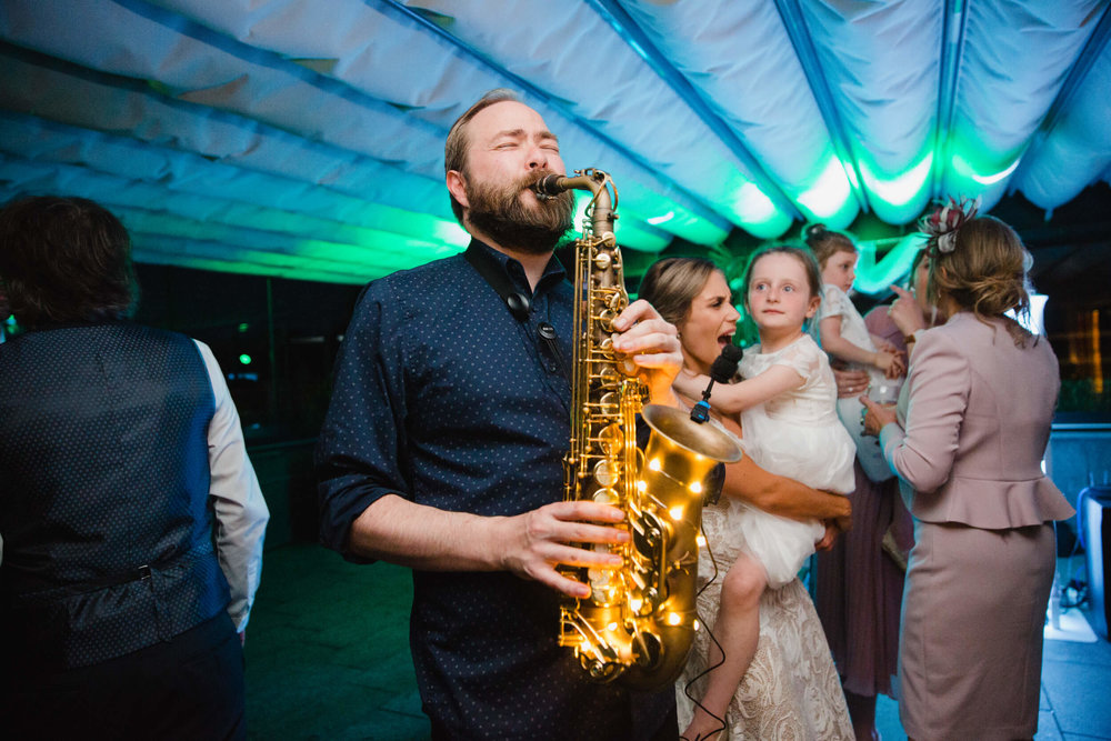 saxophone player plays to wedding party at the colony hq