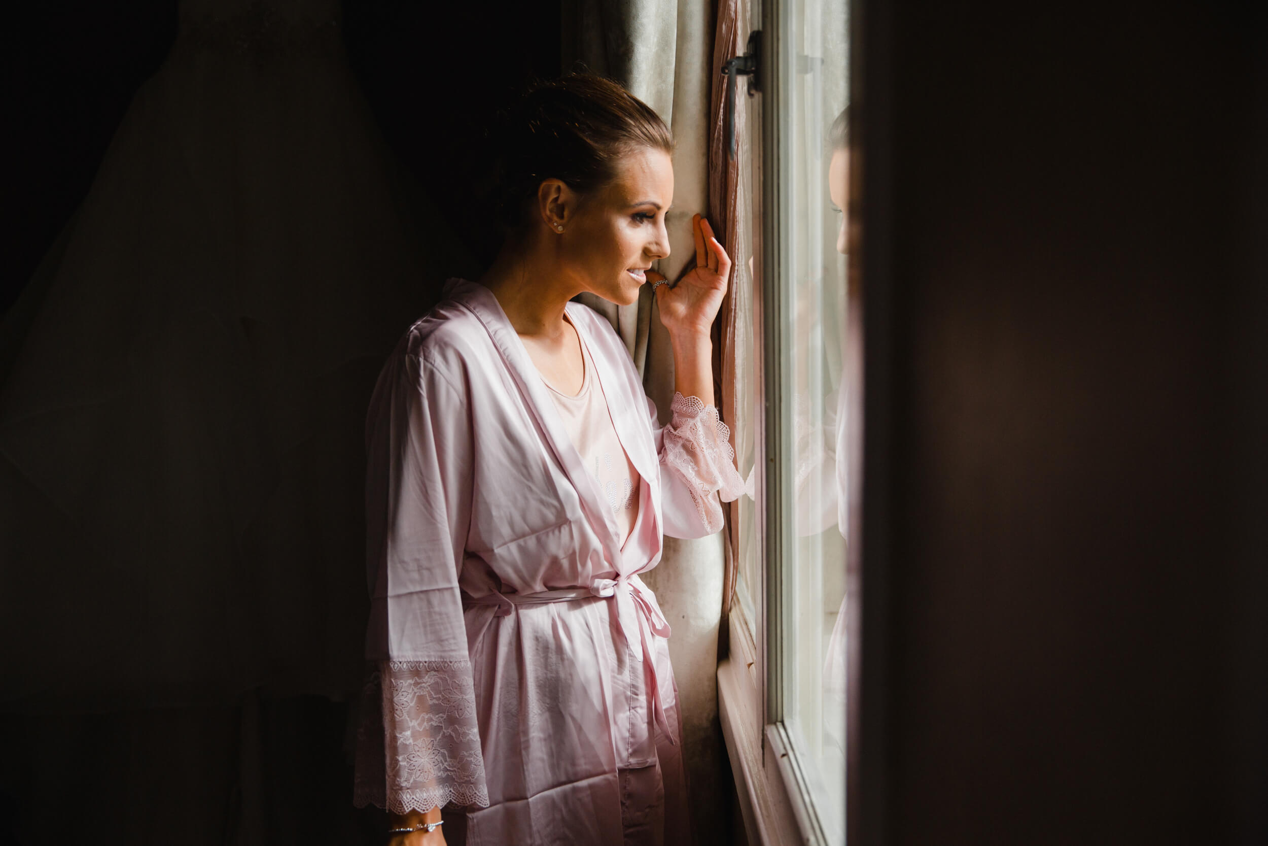 bridesmaid looking out of window down on street corner