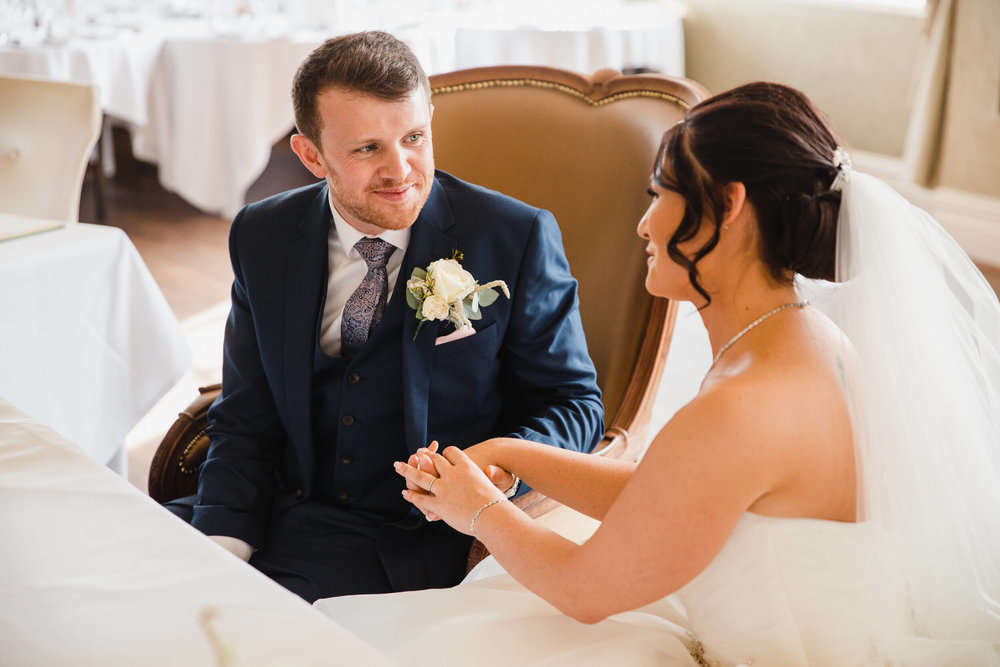 Groom holding brides hand in intimate moment