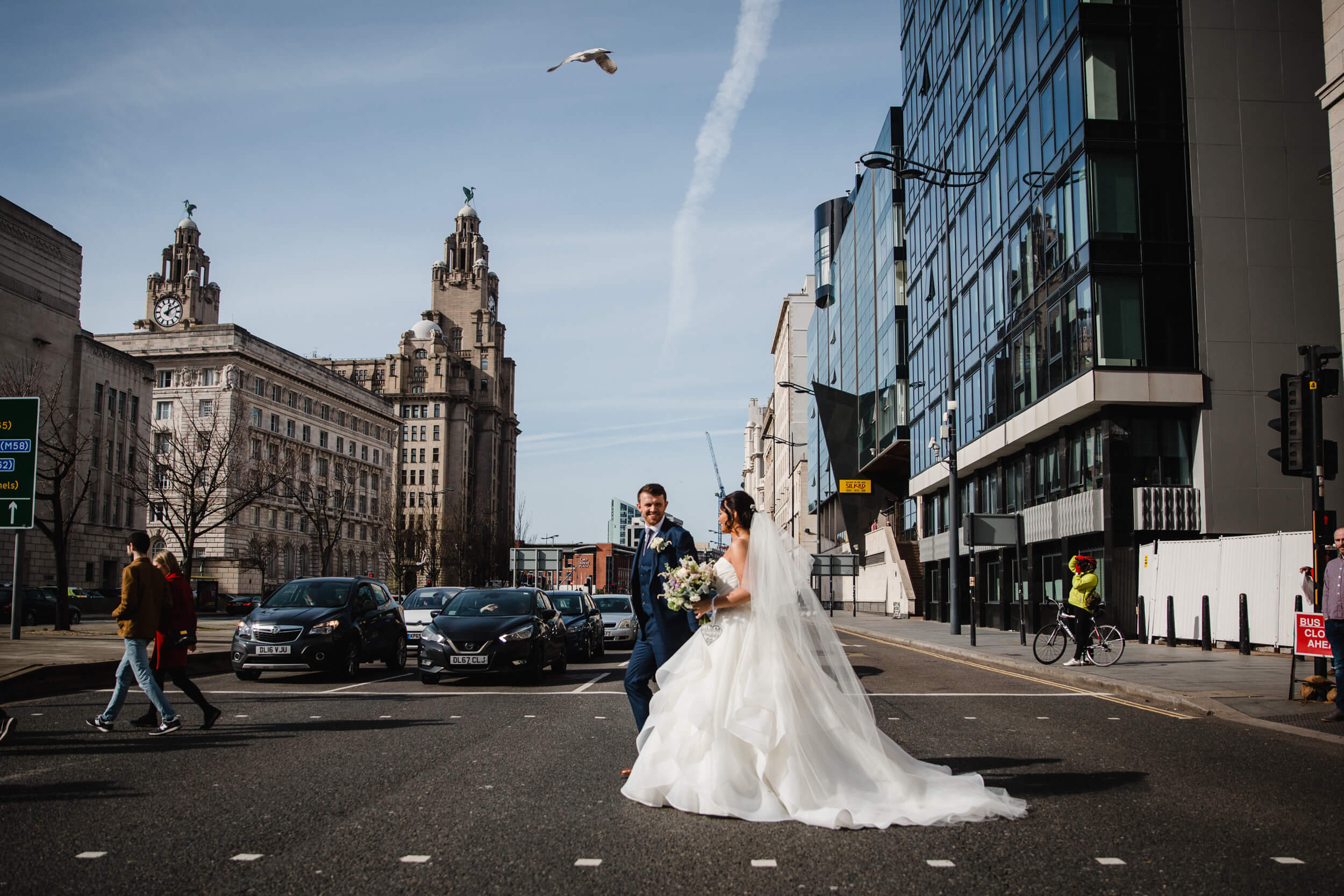 bride and groom crossing street at crossing for portraits