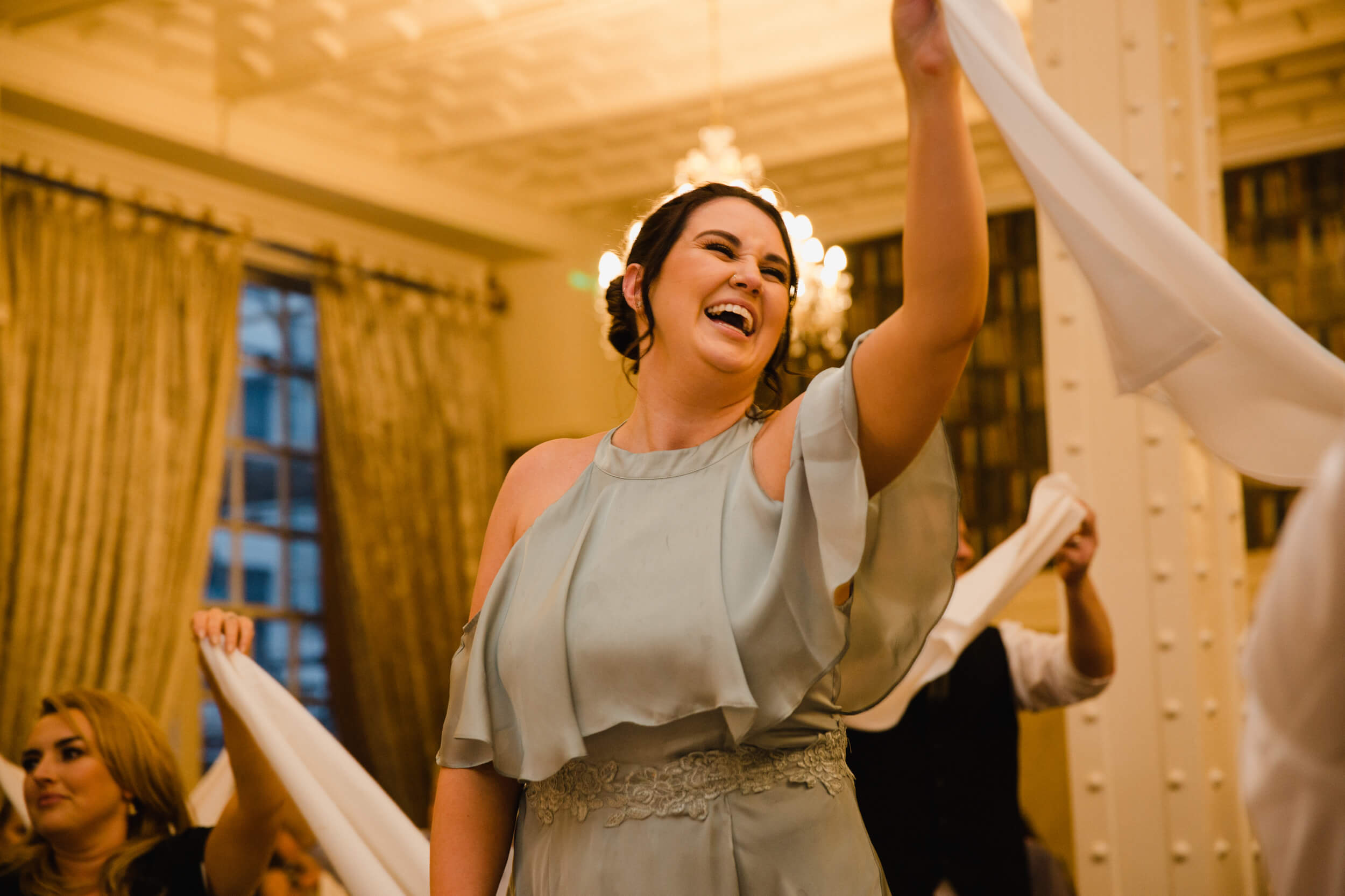 maid of honour waving napkin in the air while laughing