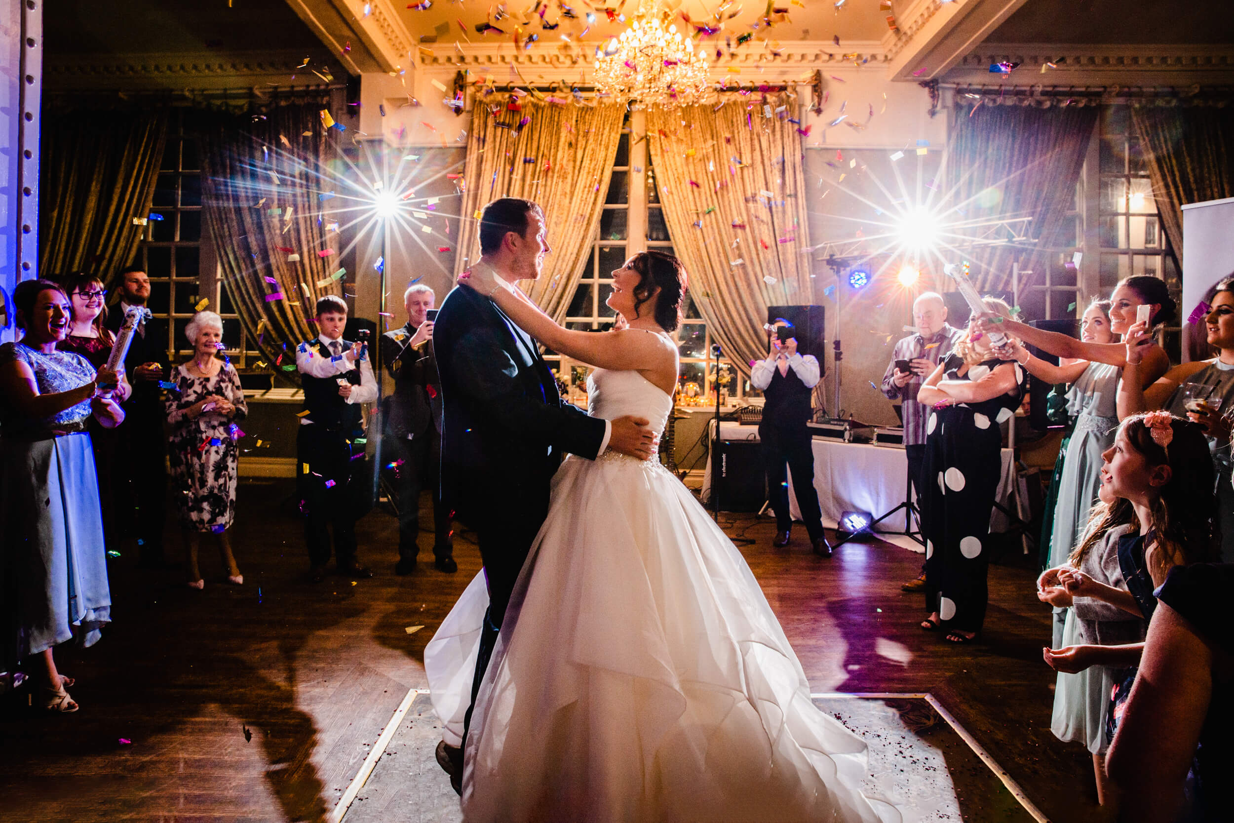 Bride and Groom first dance with confetti cannons lit up by flash and low exposure for lens