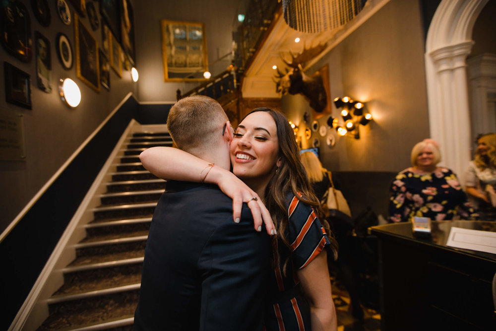 wedding guest sharing hug with groom before wedding ceremony