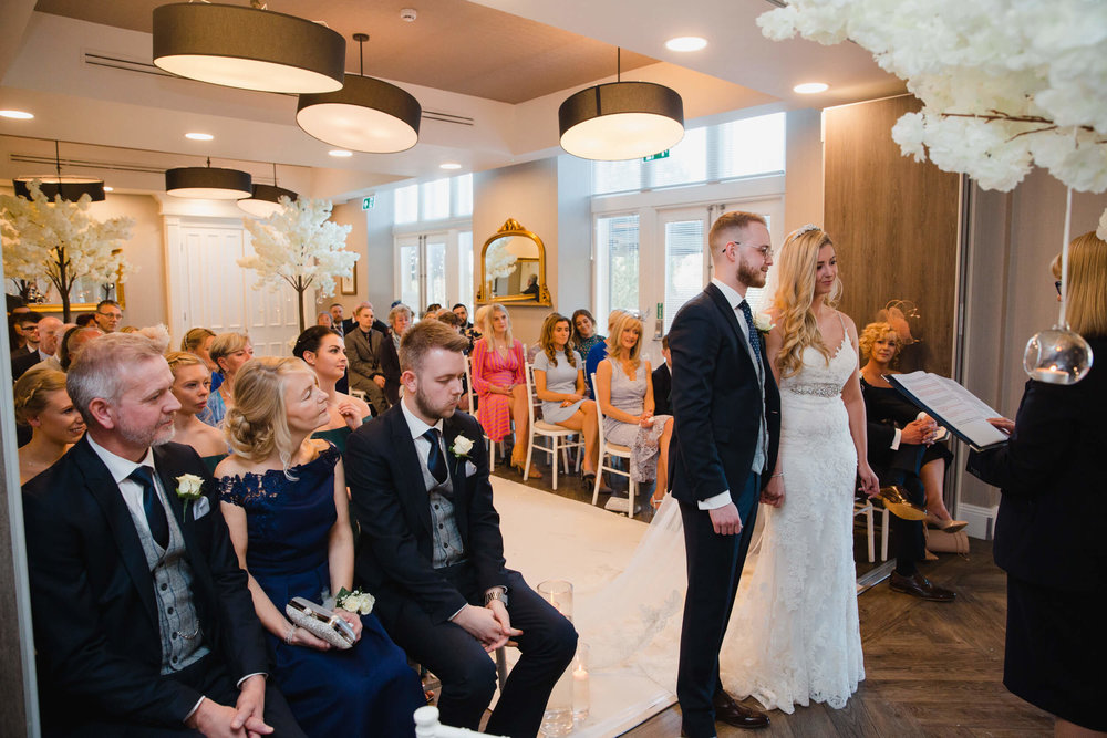wide angle lens photograph of wedded couple holding hands at oddfellows on the park