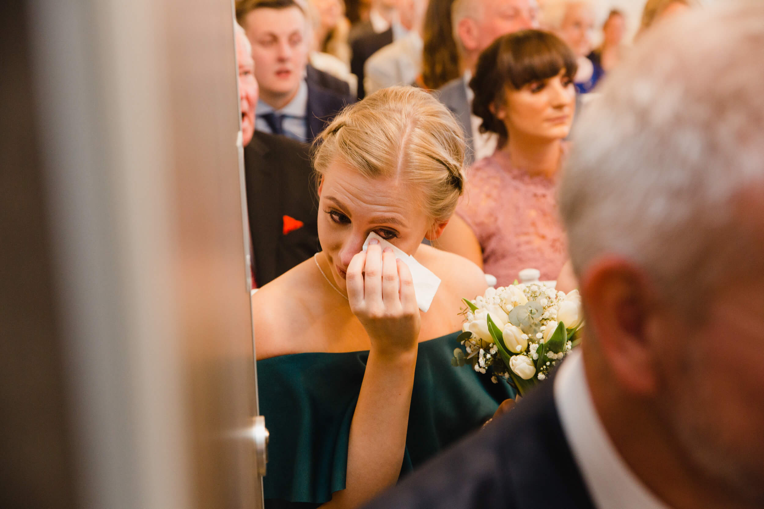 bridesmaid wiping away tear with tissue during vows at oddfellows on the park