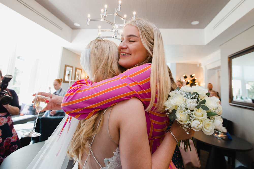 wedding guest hugs and congratulates bride