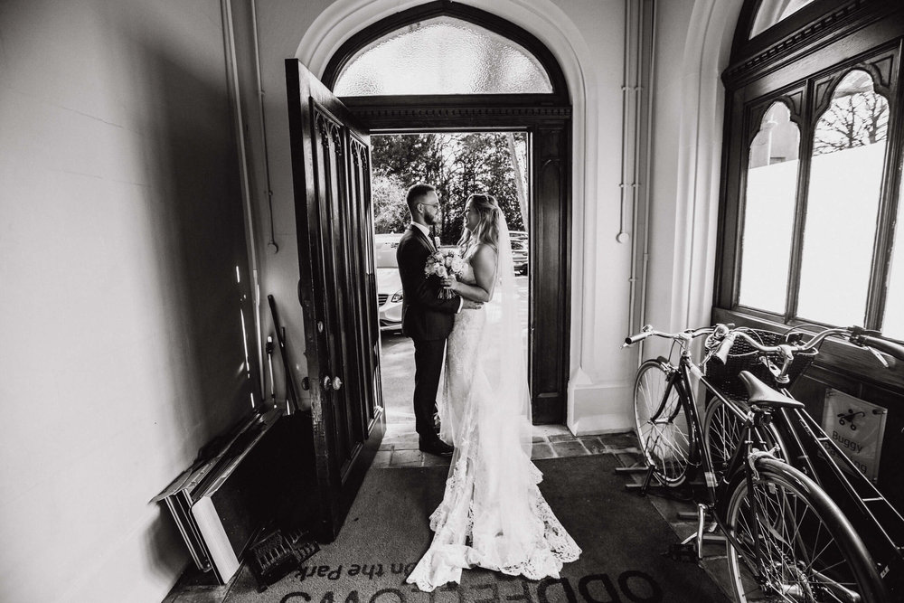 black and white portrait of newlyweds in doorway of oddfellows on the park