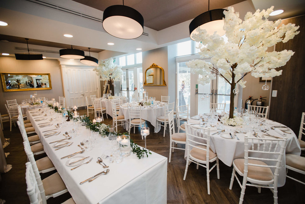 wide angle lens photograph of wedding breakfast room with blossom tree tables