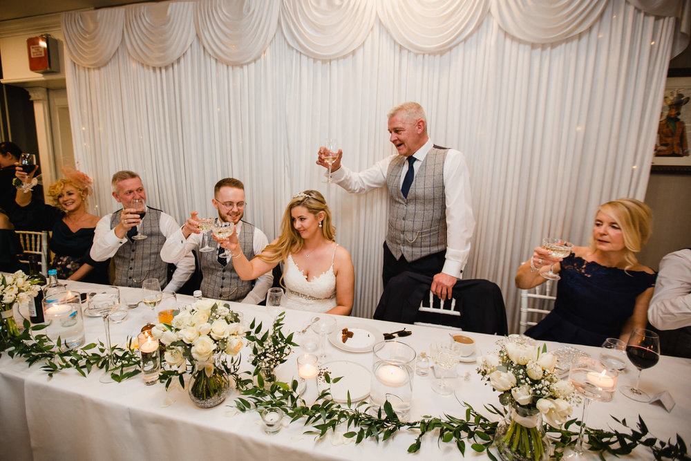 father of bride raising a toast to newlyweds during speeches