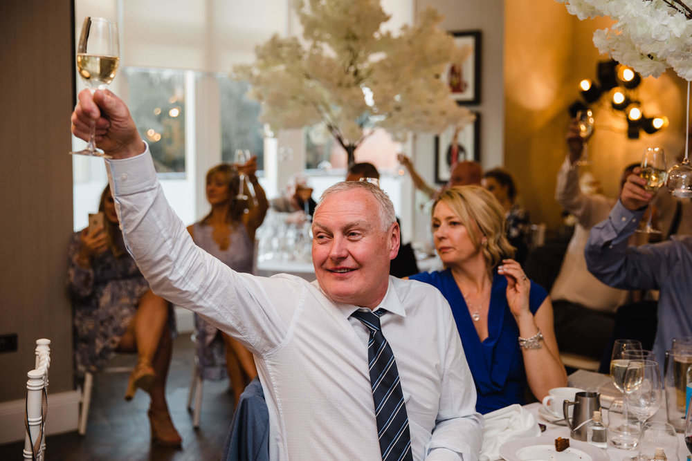 close up photograph of wedding guest holding glass of champagne