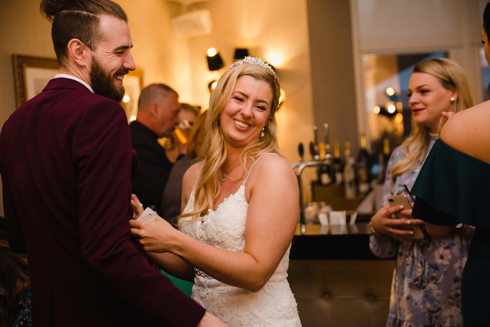 bride laughing and sharing joke with friend on dance floor