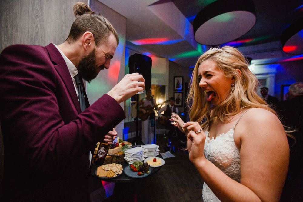 bride sharing shot with friend after first dance