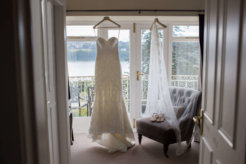 wedding dress hanging in bay windows of country house