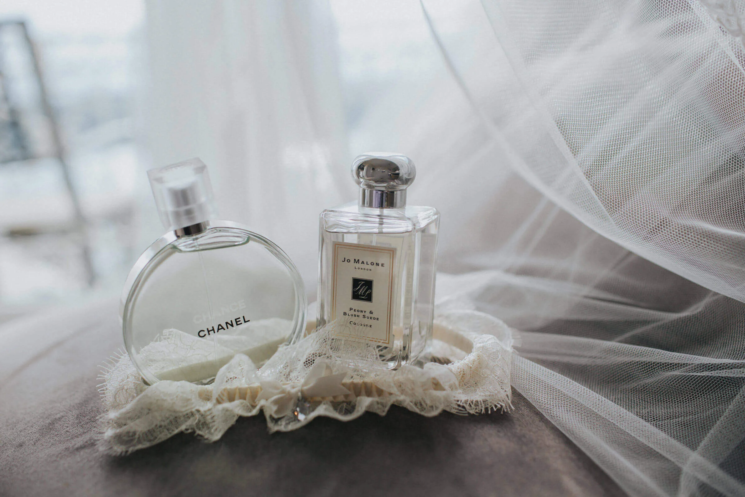 close up macro lens photograph of perfume and wedding garter on chair in villa