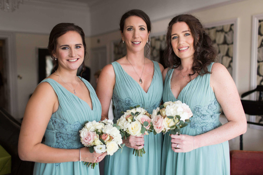 bridesmaids posing to camera while holding bouquets of flowers