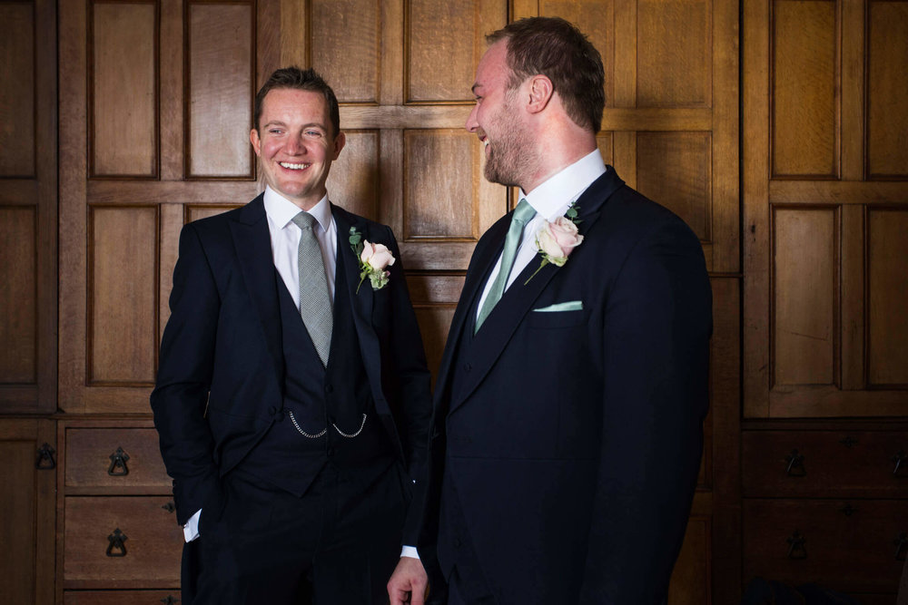 groom sharing joke with best man at chateau rhianfa