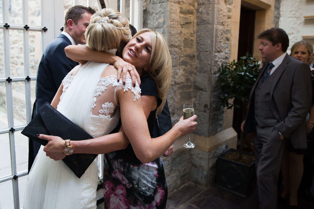 wedding guest shares hug with bride with congratulations