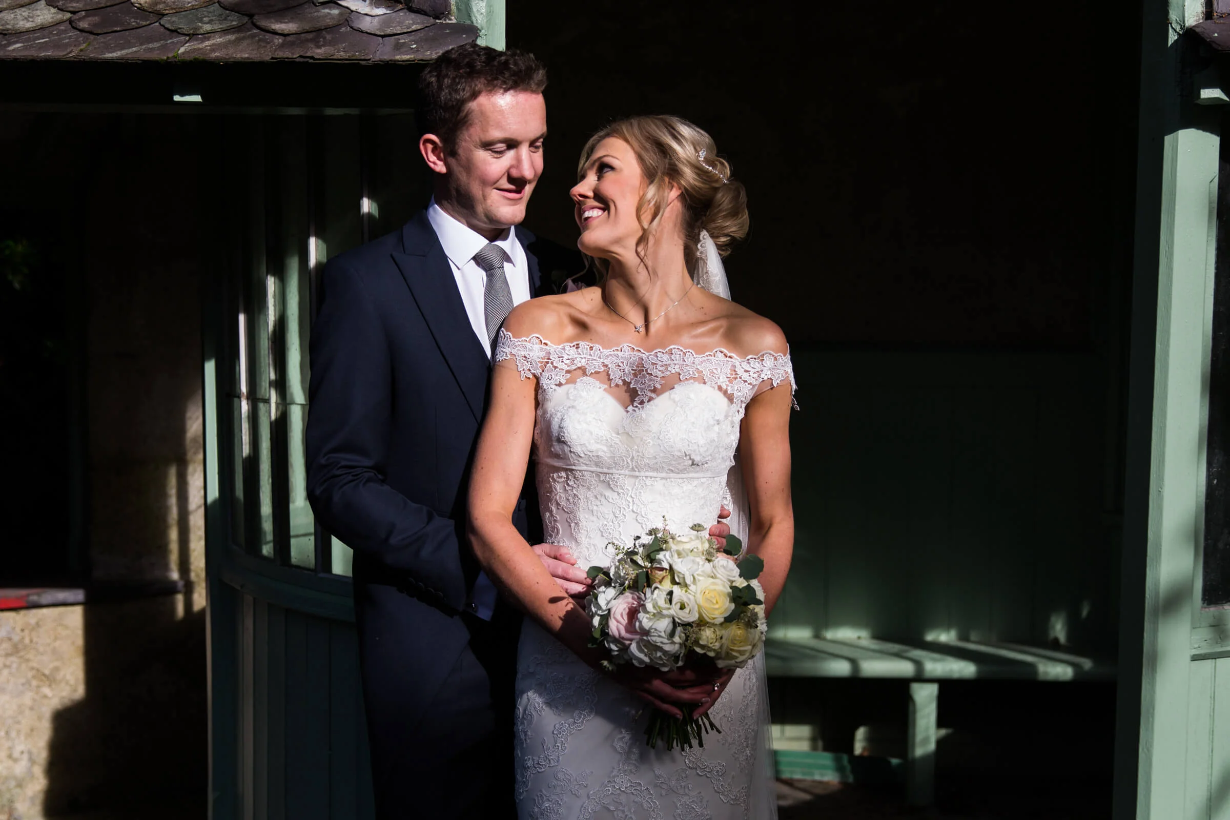 bride and groom pose for portrait by the shooting lodge entrance