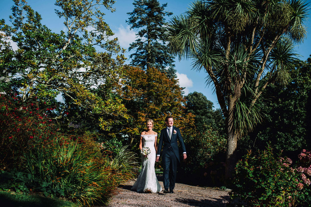 newly wedded couple walking towards camera for a quick unposed portrait in gardens of chateau rhianfa