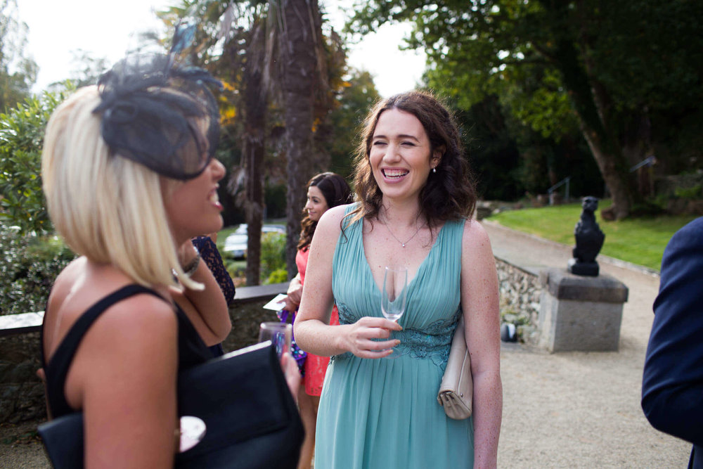 bridesmaid sharing joke with wedding guest on the villa terrace