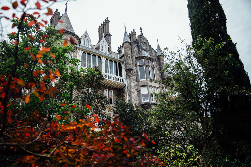 landscape photograph of chateau rhianfa with trees and bushes in the foreground