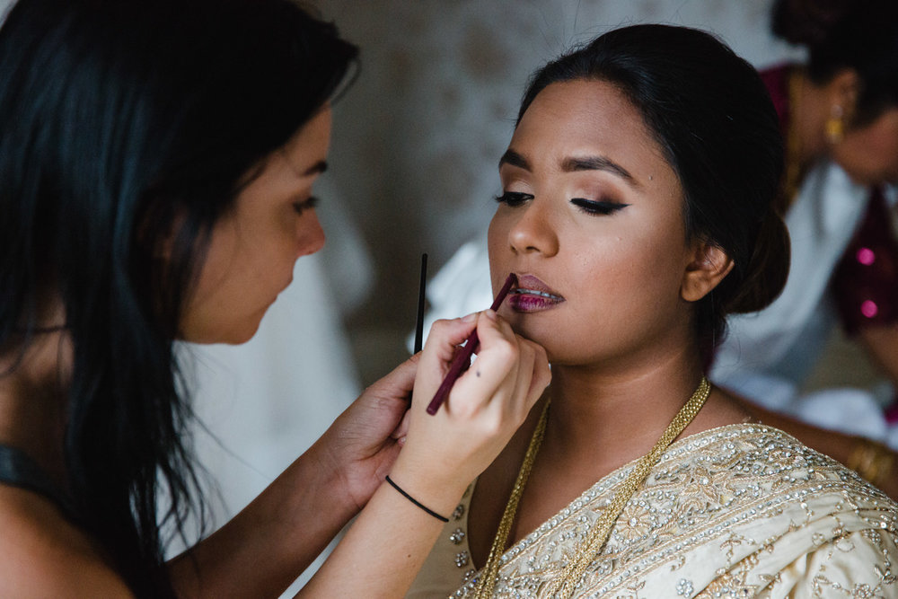 bride having make up applied to lips