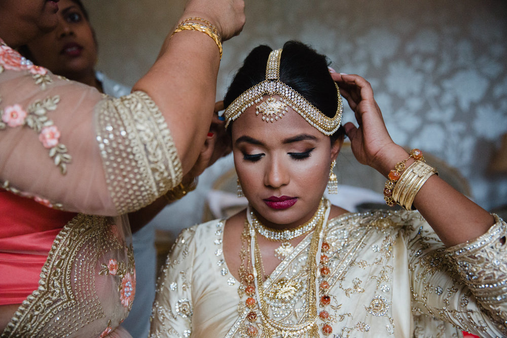 bride and maid of honour attaching headdress tiara in bridal suite