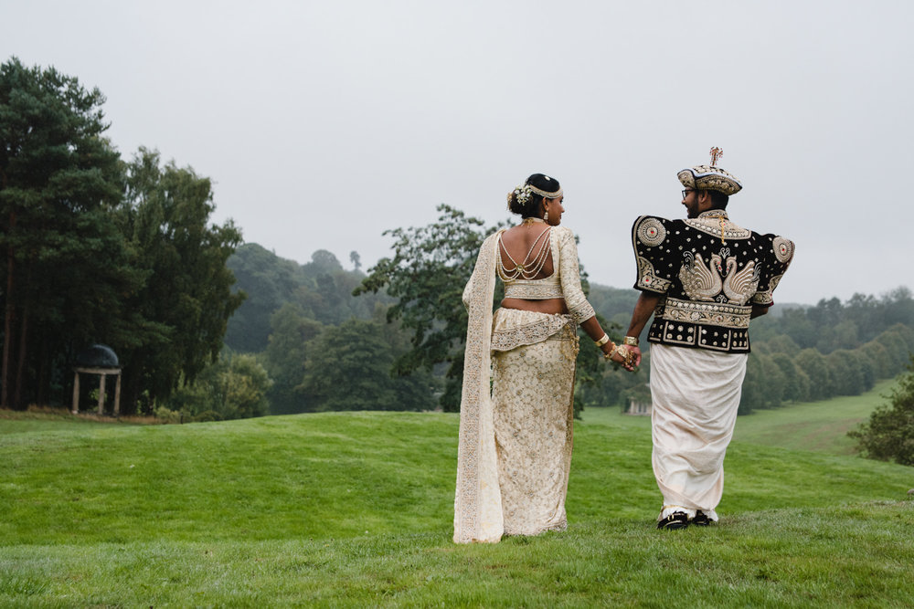 newly wedded couple walking away from camera for portrait photograph at delamere manor wedding venue