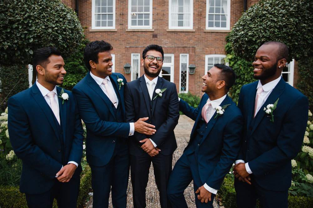 group photograph of groomsmen laughing with groom