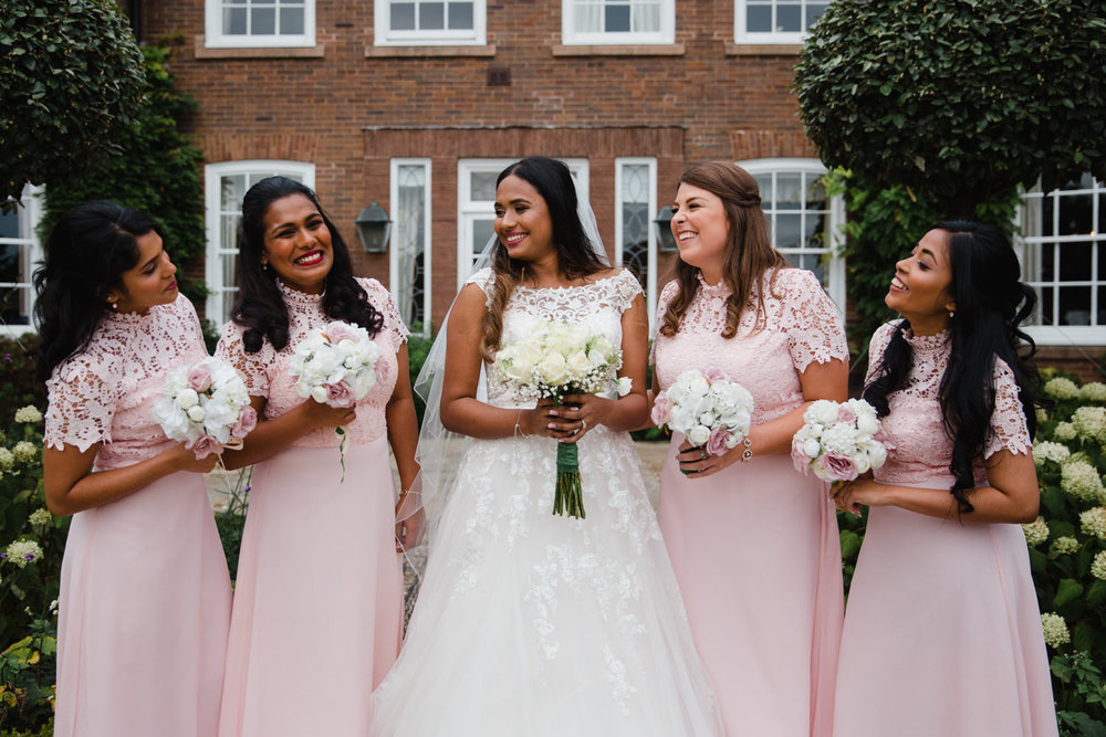 group photograph of bride posing with bridesmaids holding bouquets