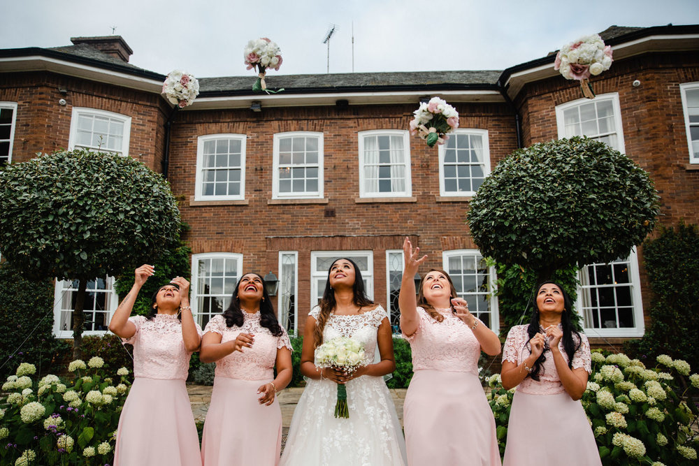 bridesmaids throw bouquets up in air like confetti at delamere manor