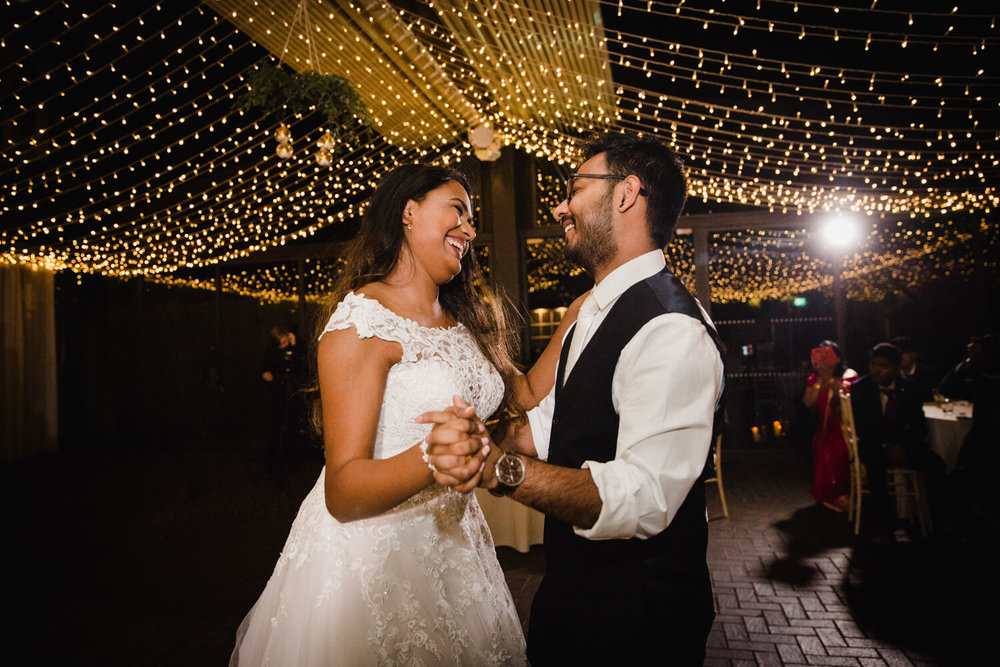 bride and groom first dance under yellow lights at delamere manor estate wedding venue