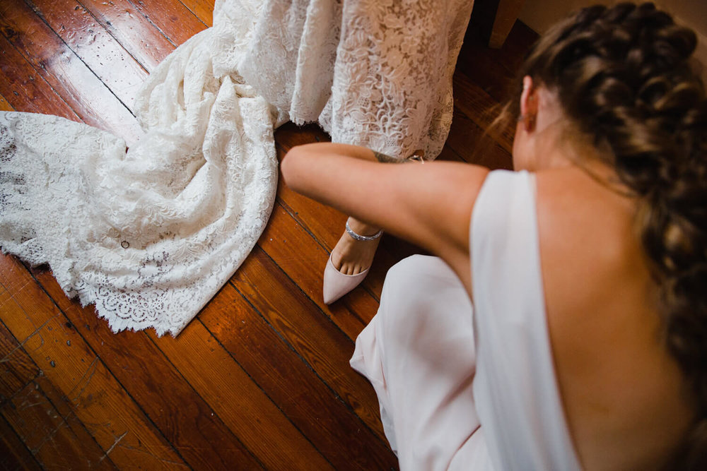 Copy of bridesmaid fastening bridal shoes at great john street