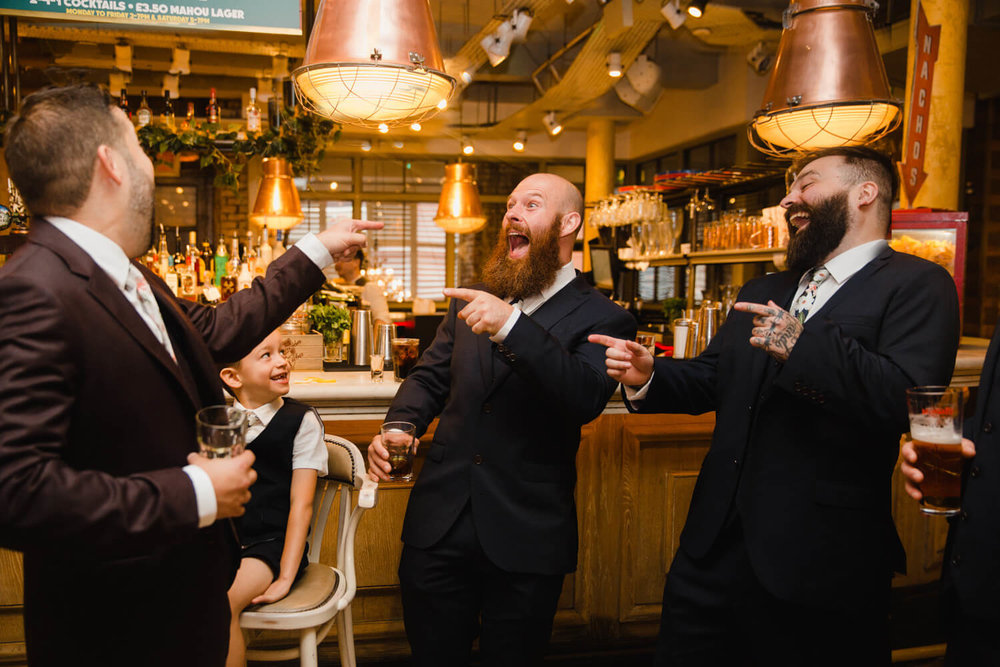 Copy of groomsmen at bar joking with groom about drinks outstanding