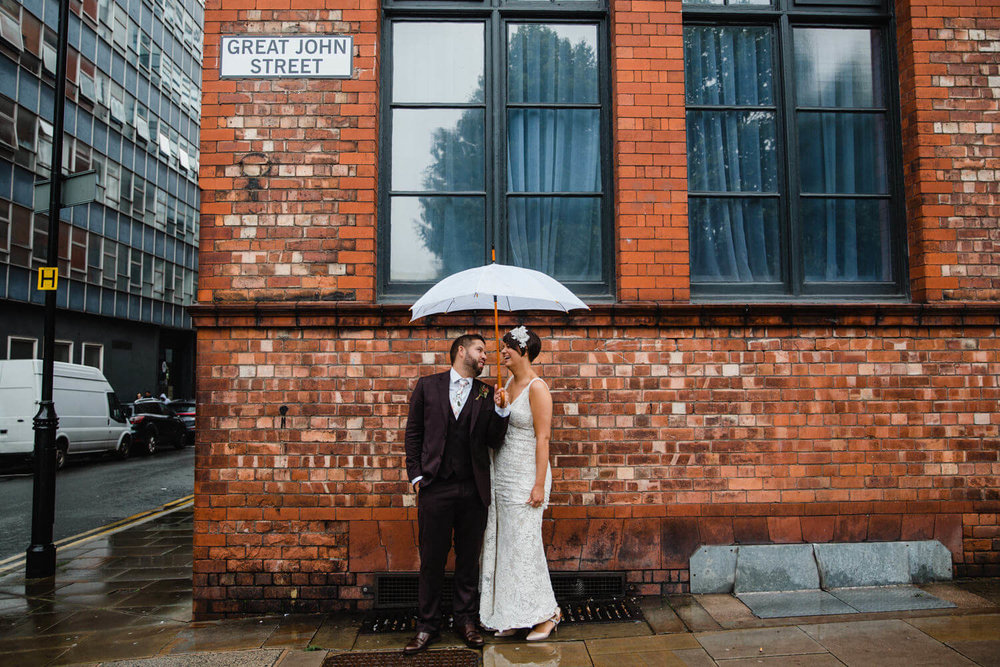 Copy of newly wedded couple holding umbrella at Great John Street Hotel