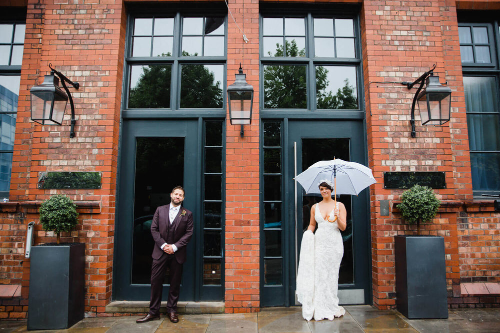 Copy of bride and groom stood in doorway for posed portrait at great john street hotel wedding photography